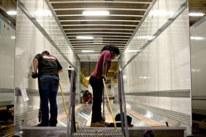 Workers drill holes to secure flooring to the frame of a semi trailer at the Wabash National Corp. facility in Lafayette Indiana