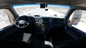 Kodiak Driverless Trucks Revolutionize Permian Oilfield Logistics shown by an Empty cab of an autonomous Kodiak RoboTruck driving on a remote West Texas road with no driver in the seat.