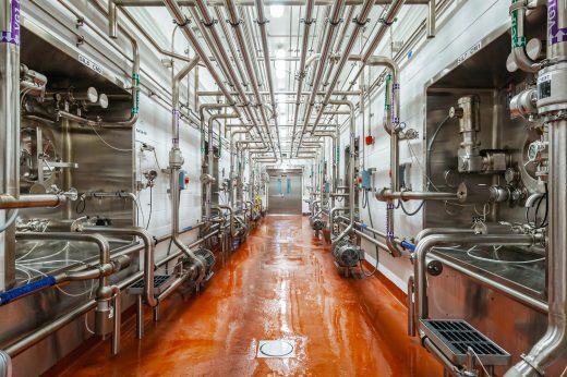 Stainless-steel dairy-processing pipes and raw-product tanks inside a Ninth Avenue Foods facility.