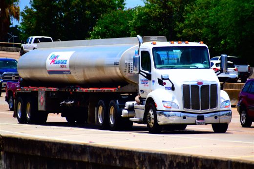 Silver gasoline tanker truck traveling on a divided interstate highway.
