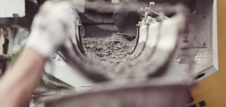 Wet concrete flowing down a mixer truck’s discharge chute.
Media title: Concrete Delivery and Construction Cost Pressure